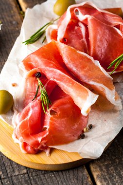 prosciutto ile karışık zeytin ve ahşap kesme tahtası üzerinde kırmızı biber ince dilim closeup