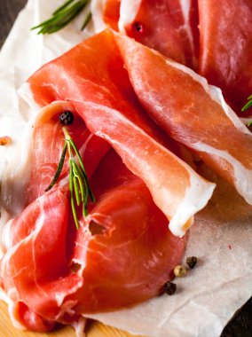 prosciutto ile karışık zeytin ve ahşap kesme tahtası üzerinde kırmızı biber ince dilim closeup