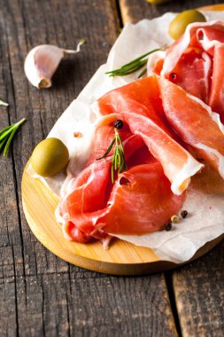 prosciutto ile karışık zeytin ve ahşap kesme tahtası üzerinde kırmızı biber ince dilim closeup