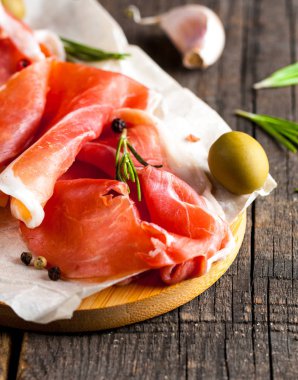 prosciutto ile karışık zeytin ve ahşap kesme tahtası üzerinde kırmızı biber ince dilim closeup