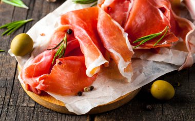 prosciutto ile karışık zeytin ve ahşap kesme tahtası üzerinde kırmızı biber ince dilim closeup