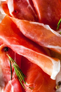 prosciutto ile karışık zeytin ve ahşap kesme tahtası üzerinde kırmızı biber ince dilim closeup