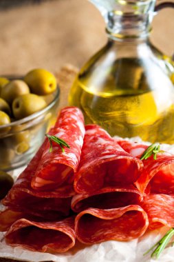 Zeytin ve ahşap zemin üzerine baharat ile İtalyan salamı