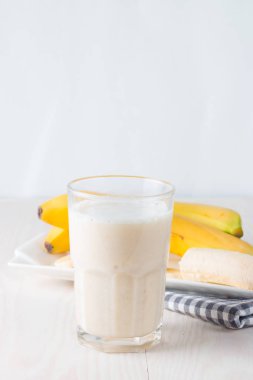 Taze yapılmış çikolata muz Smoothie ahşap bir masa üzerinde. Seçici odak. Bademli muzlu süt. Protein diyeti. Sağlıklı yiyecek ve içecek konsepti.