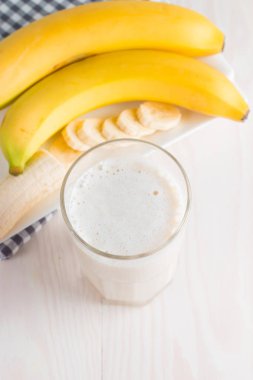 Taze yapılmış çikolata muz Smoothie ahşap bir masa üzerinde. Seçici odak. Bademli muzlu süt. Protein diyeti. Sağlıklı yiyecek ve içecek konsepti.
