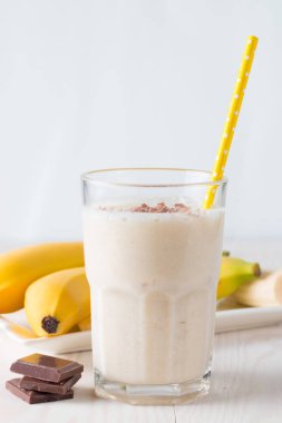 Taze yapılmış çikolata muz Smoothie ahşap bir masa üzerinde. Seçici odak. Bademli muzlu süt. Protein diyeti. Sağlıklı yiyecek ve içecek konsepti.