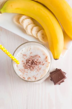 Taze yapılmış çikolata muz Smoothie ahşap bir masa üzerinde. Seçici odak. Bademli muzlu süt. Protein diyeti. Sağlıklı yiyecek ve içecek konsepti.