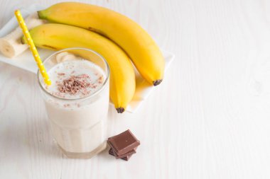 Taze yapılmış çikolata muz Smoothie ahşap bir masa üzerinde. Seçici odak. Bademli muzlu süt. Protein diyeti. Sağlıklı yiyecek ve içecek konsepti.