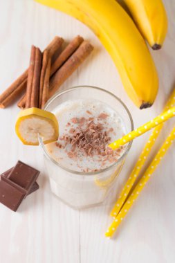 Taze yapılmış çikolata muz Smoothie ahşap bir masa üzerinde. Seçici odak. Bademli muzlu süt. Protein diyeti. Sağlıklı yiyecek ve içecek konsepti.