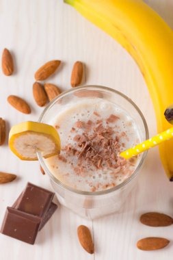 Taze yapılmış çikolata muz Smoothie ahşap bir masa üzerinde. Seçici odak. Bademli muzlu süt. Protein diyeti. Sağlıklı yiyecek ve içecek konsepti.