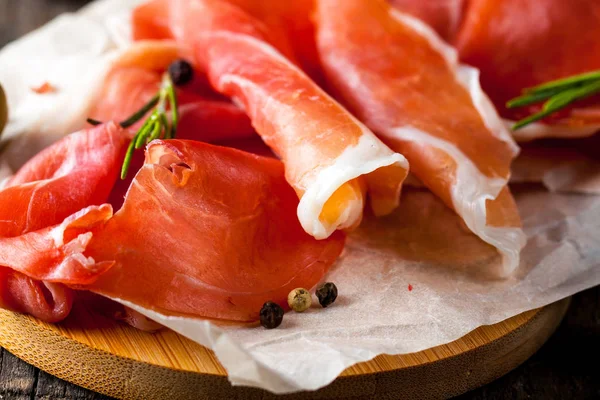 prosciutto ile karışık zeytin ve ahşap kesme tahtası üzerinde kırmızı biber ince dilim closeup