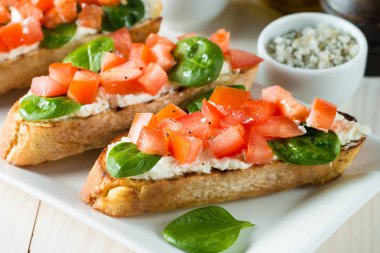 Domates ve peynirli taze yapılmış bruschetta. İtalyan tapas antipasti sebzeler, otlar ve ızgara ciabatta ve baget ekmek üzerine. Sandviç.