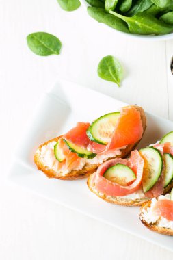 Somon, salatalık ve krem peynir bruschetta. İtalyan tapas antipasti sebzeler, otlar ve ızgara ciabatta ve baget ekmek üzerine. Sandviç.