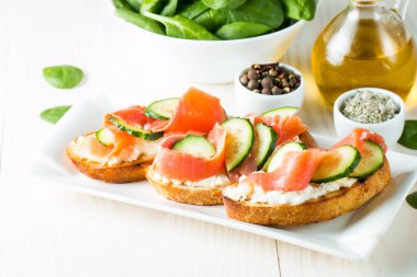 Somon, salatalık ve krem peynir bruschetta. İtalyan tapas antipasti sebzeler, otlar ve ızgara ciabatta ve baget ekmek üzerine. Sandviç.