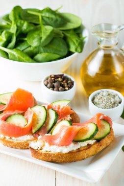 Somon, salatalık ve krem peynir bruschetta. İtalyan tapas antipasti sebzeler, otlar ve ızgara ciabatta ve baget ekmek üzerine. Sandviç.