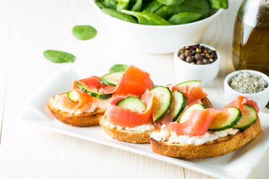 Somon, salatalık ve krem peynir bruschetta. İtalyan tapas antipasti sebzeler, otlar ve ızgara ciabatta ve baget ekmek üzerine. Sandviç.
