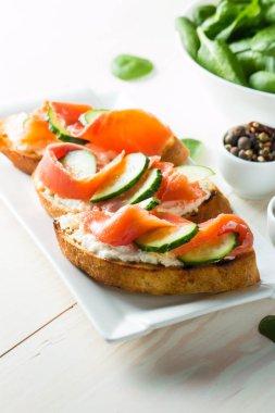 Somon, salatalık ve krem peynir bruschetta. İtalyan tapas antipasti sebzeler, otlar ve ızgara ciabatta ve baget ekmek üzerine. Sandviç.