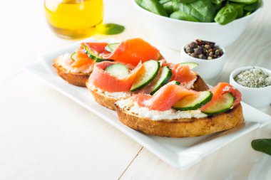 Somon, salatalık ve krem peynir bruschetta. İtalyan tapas antipasti sebzeler, otlar ve ızgara ciabatta ve baget ekmek üzerine. Sandviç.