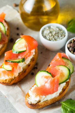Somon, salatalık ve krem peynir bruschetta. İtalyan tapas antipasti sebzeler, otlar ve ızgara ciabatta ve baget ekmek üzerine. Sandviç.