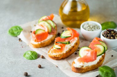 Somon, salatalık ve krem peynir bruschetta. İtalyan tapas antipasti sebzeler, otlar ve ızgara ciabatta ve baget ekmek üzerine. Sandviç.