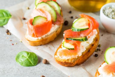 Somon, salatalık ve krem peynir bruschetta. İtalyan tapas antipasti sebzeler, otlar ve ızgara ciabatta ve baget ekmek üzerine. Sandviç.