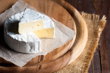 Brie peyniri. Camembert peyniri. Taze Brie peyniri ve tahtadan bir dilim fındık, bal ve yaprakla. İtalyan, Fransız peyniri.