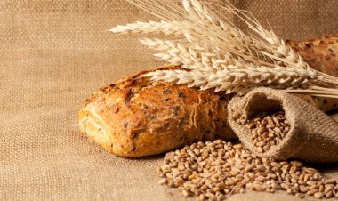 Retro bread in rustic style background.Fresh traditional bread on wooden ground with flour in a sack.