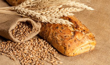 Retro bread in rustic style background.Fresh traditional bread on wooden ground with flour in a sack.