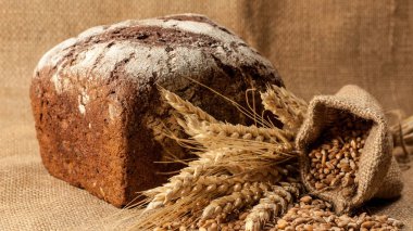 Retro bread in rustic style background.Fresh traditional bread on wooden ground with flour in a sack.