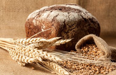 Retro bread in rustic style background.Fresh traditional bread on wooden ground with flour in a sack.