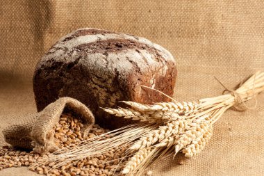 Retro bread in rustic style background.Fresh traditional bread on wooden ground with flour in a sack.