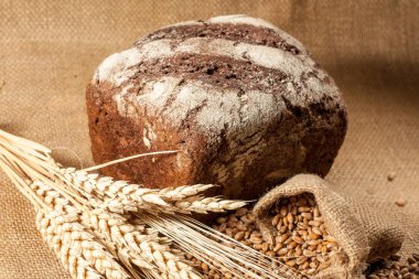 Retro bread in rustic style background.Fresh traditional bread on wooden ground with flour in a sack.