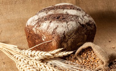 Retro bread in rustic style background.Fresh traditional bread on wooden ground with flour in a sack.