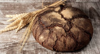 Retro bread in rustic style background.Fresh traditional bread on wooden ground with flour in a sack.