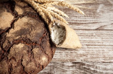 Retro bread in rustic style background.Fresh traditional bread on wooden ground with flour in a sack.