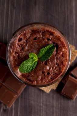 Çikolata, kahve, süt, muz sallamak ahşap arka plan üzerinde. Nane ile güler yüzlü. Milkshake. Protein diyeti. Sağlıklı yiyecek ve içecek konsepti.