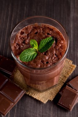 Çikolata, kahve, süt, muz sallamak ahşap arka plan üzerinde. Nane ile güler yüzlü. Milkshake. Protein diyeti. Sağlıklı yiyecek ve içecek konsepti.