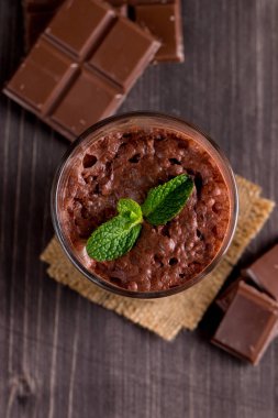 Çikolata, kahve, süt, muz sallamak ahşap arka plan üzerinde. Nane ile güler yüzlü. Milkshake. Protein diyeti. Sağlıklı yiyecek ve içecek konsepti.