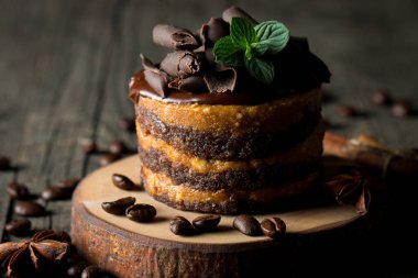 Çikolatalı kek siyah slatter kurulu ile nane, kahve çekirdekleri koyu arka plan, closeup fotoğraf üzerinde. Taze, lezzetli tatlı gıda kavramı. 