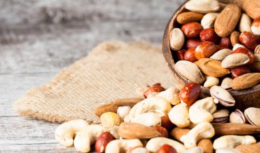 Ahşap arka plan üzerinde sağlıklı karışımı fındık. Badem, fındık, kaju fıstığı, fıstık, Antep fıstığı, Brezilya fındık