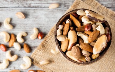 Ahşap arka plan üzerinde sağlıklı karışımı fındık. Badem, fındık, kaju fıstığı, fıstık, Antep fıstığı, Brezilya fındık