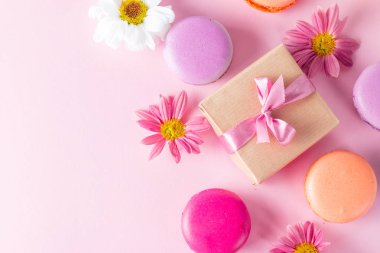 Pasta macarons, hediye kutusu, çay, kahve, cappuccino ve çiçek fotoğrafı. Tatlı romantik gıda acıbadem kurabiyesi kavramı. Sabah kahvaltı ve hediyeler. Sevgililer günü kavramı.