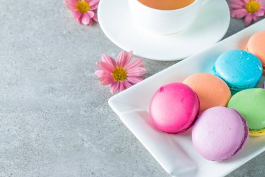 Pasta macarons, hediye kutusu, çay, kahve, cappuccino ve çiçek fotoğrafı. Tatlı romantik gıda acıbadem kurabiyesi kavramı. Sabah kahvaltı ve hediyeler. Sevgililer günü kavramı.