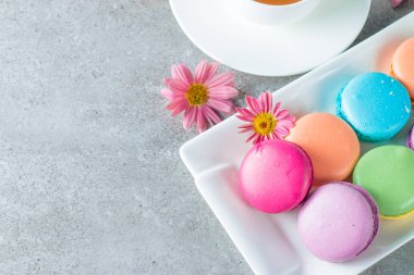 Pasta macarons, hediye kutusu, çay, kahve, cappuccino ve çiçek fotoğrafı. Tatlı romantik gıda acıbadem kurabiyesi kavramı. Sabah kahvaltı ve hediyeler. Sevgililer günü kavramı.