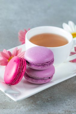 Pasta macarons, hediye kutusu, çay, kahve, cappuccino ve çiçek fotoğrafı. Tatlı romantik gıda acıbadem kurabiyesi kavramı. Sabah kahvaltı ve hediyeler. Sevgililer günü kavramı.