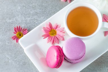 Pasta macarons, hediye kutusu, çay, kahve, cappuccino ve çiçek fotoğrafı. Tatlı romantik gıda acıbadem kurabiyesi kavramı. Sabah kahvaltı ve hediyeler. Sevgililer günü kavramı.
