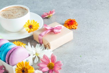 Pasta macarons, hediye kutusu, çay, kahve, cappuccino ve çiçek fotoğrafı. Tatlı romantik gıda acıbadem kurabiyesi kavramı. Sabah kahvaltı ve hediyeler. Sevgililer günü kavramı.