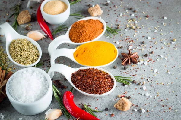 Tahta kaşık içinde baharatlar. Otlar. Köri, safran, zerdeçal, biberiye, tarçın, sarımsak, biber, anason ahşap rustik arka plan üzerinde. Baharatlar ve otlar topluluğu. Tuz, kırmızı biber. Uzay kopyalayın. Üstten görünüm. Afiş. Düz yatıyordu.