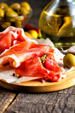 prosciutto ile karışık zeytin ve ahşap kesme tahtası üzerinde kırmızı biber ince dilim closeup