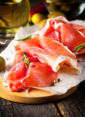 prosciutto ile karışık zeytin ve ahşap kesme tahtası üzerinde kırmızı biber ince dilim closeup